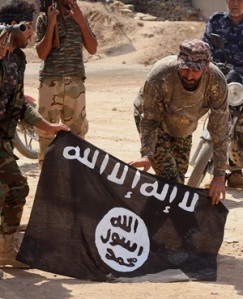 FILE - In this Tuesday, Oct . 7,  2014  file photo, Iraqi security forces hold a flag of the Islamic State group they captured during an operation outside Amirli, some 105 miles (170 kilometers) north of Baghdad, Iraq. The Islamic State group may be sprouting tentacles across the region but it is struggling in Syria, part of its heartland, where it has stalled or even lost ground in fighting with multiple enemies on multiple fronts. There are signs of tensions and powers struggles emerging among its ranks of foreign jihadis. (AP Photo, File)